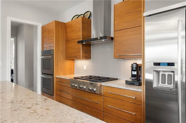 a kitchen with stainless steel appliances granite countertop a refrigerator and a stove