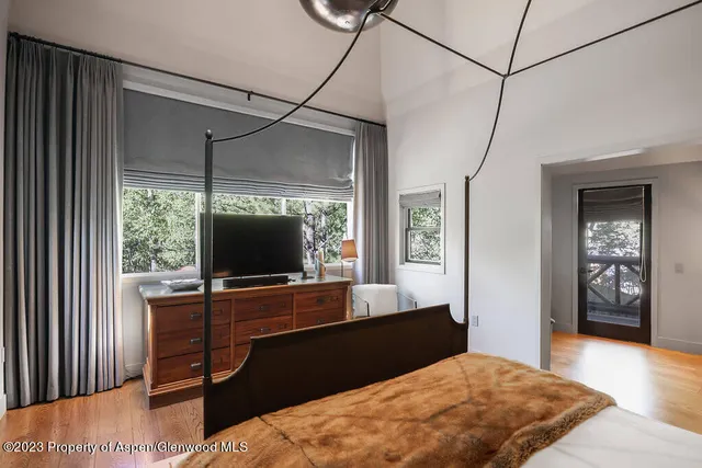 a bedroom with a bed a table and potted plant