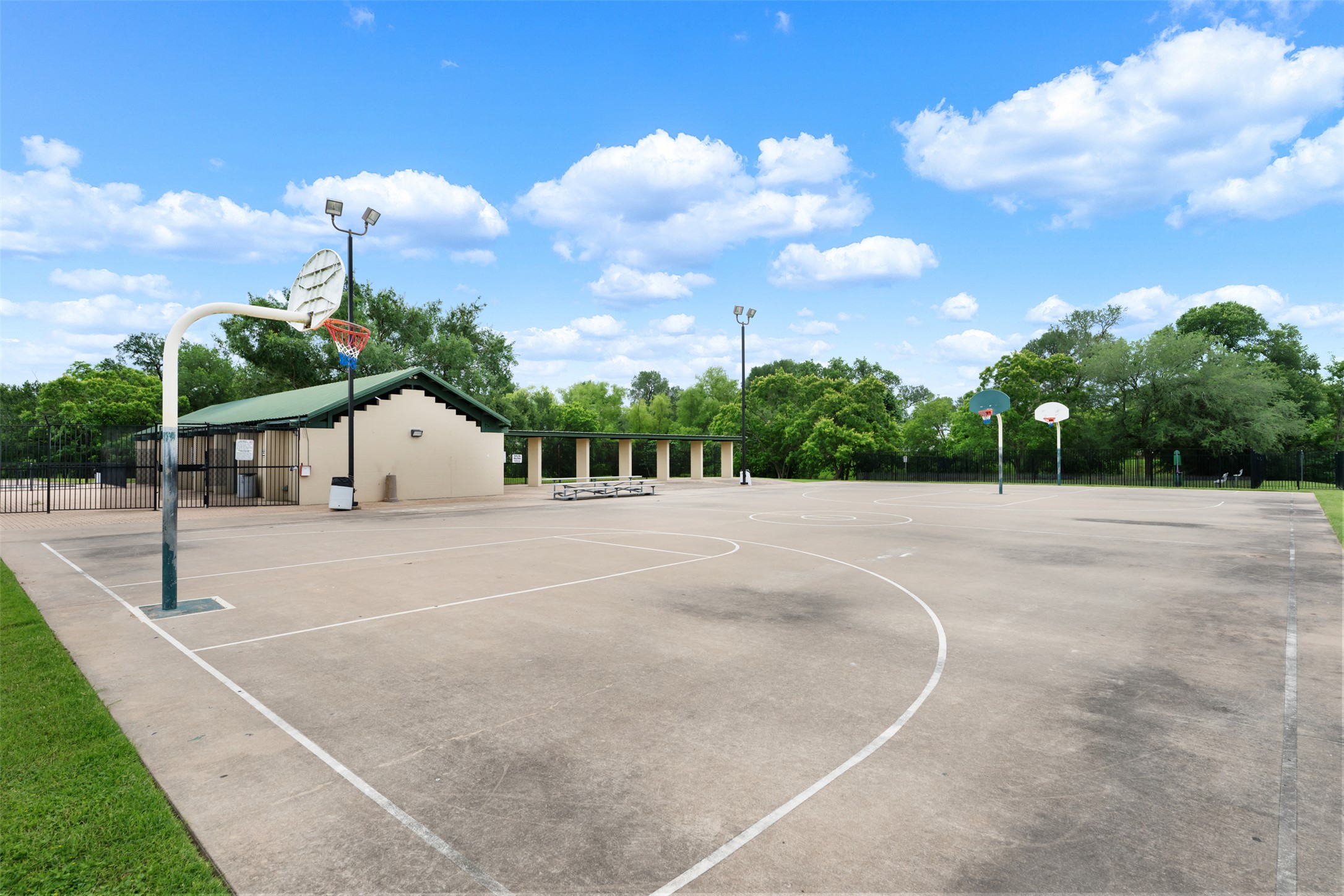 14900 Retha Pass Austin, TX 78725 - Photo 34 of 39 Outdoor multi-sport court featuring multiple basketball hoops and court markings on a concrete surface