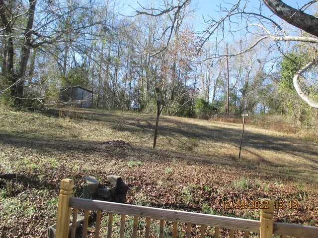 a view of a yard with wooden fence