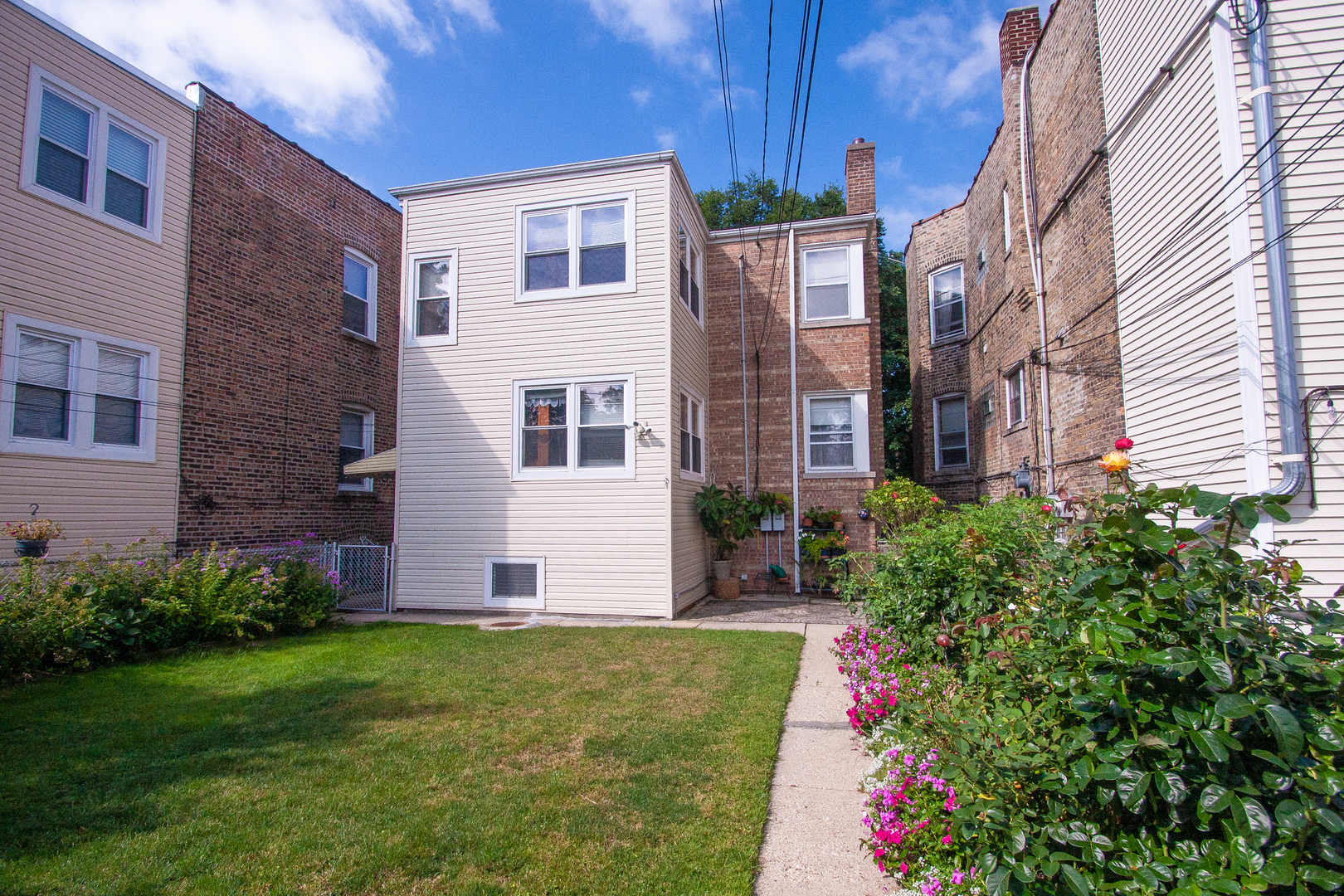3909 North Spaulding Avenue Chicago, IL 60618 - Photo 20 of 20 a view of a house with brick walls and a yard with plants
