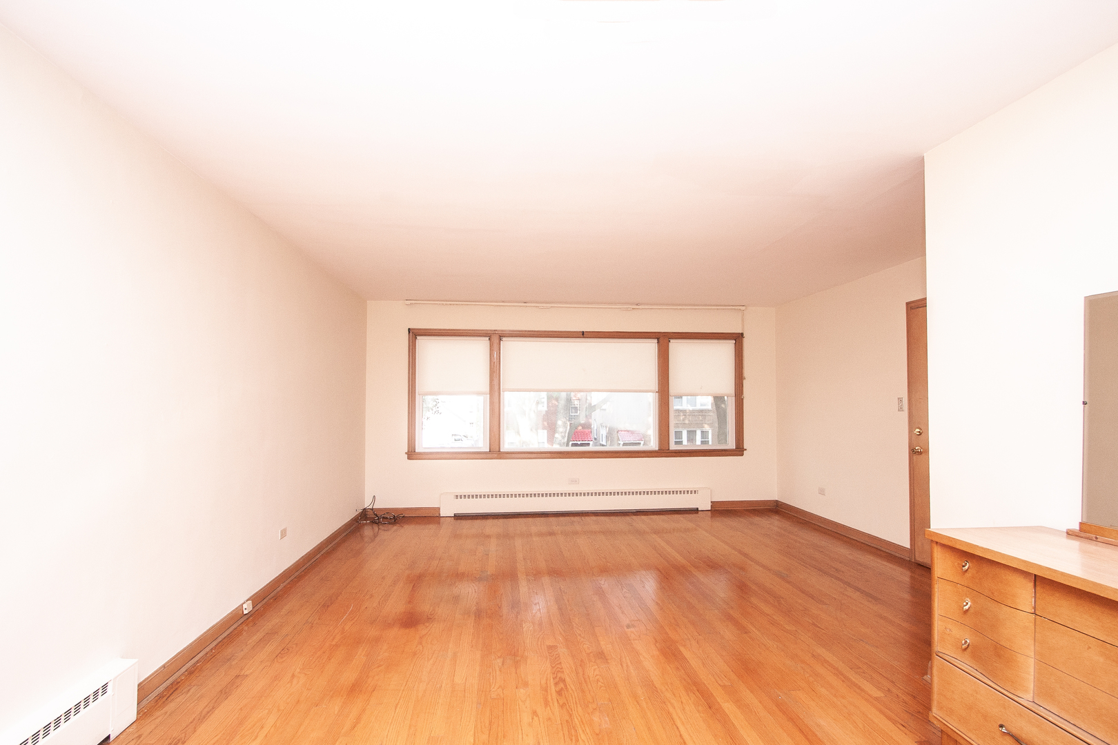 3909 North Spaulding Avenue Chicago, IL 60618 - Photo 2 of 20 an empty room with wooden floor and windows