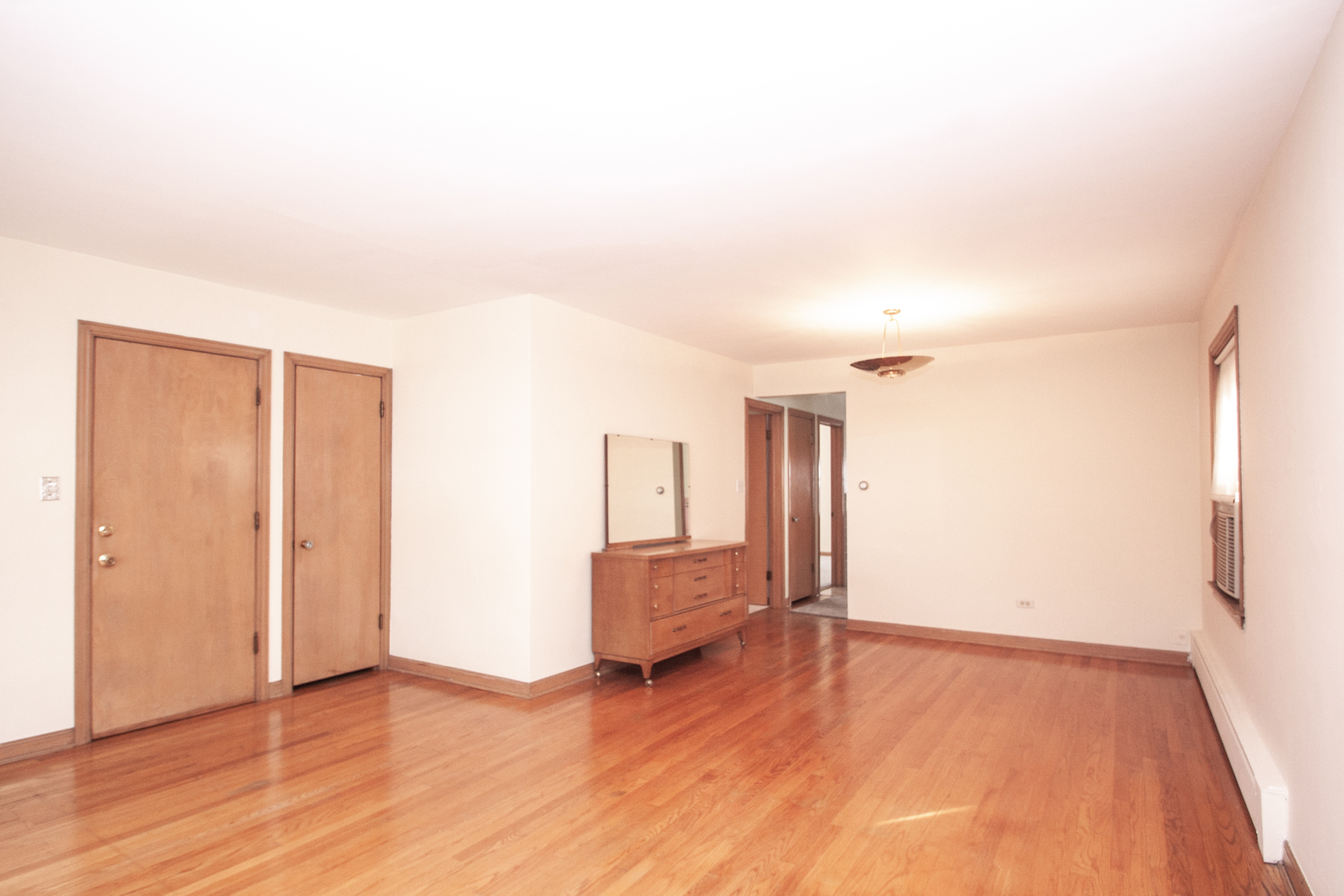 3909 North Spaulding Avenue Chicago, IL 60618 - Photo 4 of 20 an empty room with wooden floor and windows