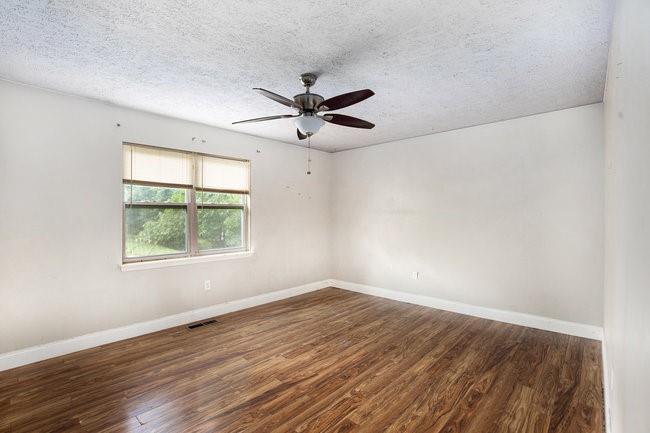 8955 Ochil Lane Winston, GA 30187 - Photo 17 of 31 an empty room with wooden floor and windows