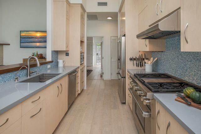 a kitchen with stainless steel appliances granite countertop a sink stove and refrigerator