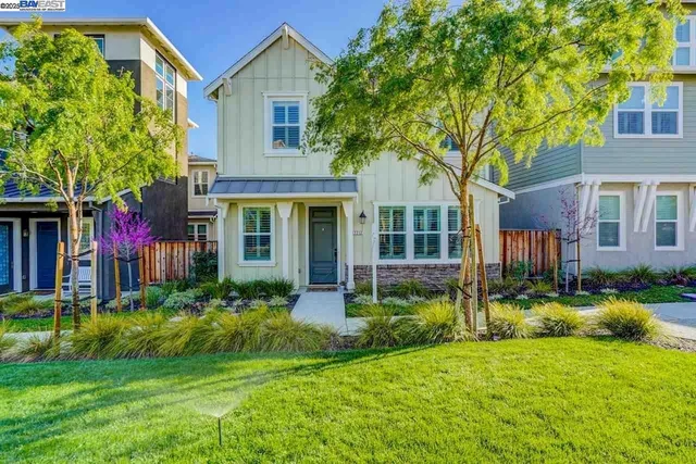 a front view of a house with a yard and potted plants