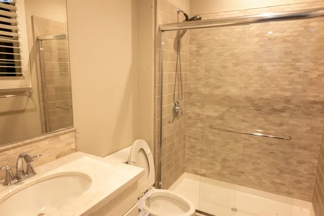 a bathroom with a sink toilet and shower