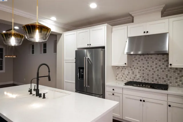 a kitchen with stainless steel appliances a sink a stove a refrigerator and cabinets
