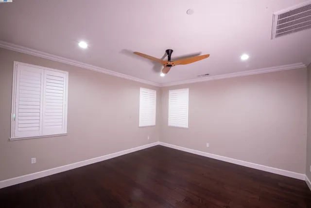 a view of a room with wooden floor and a ceiling fan