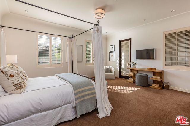 a bedroom with furniture and large windows