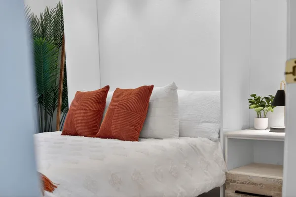 a bedroom with a bed and a potted plant