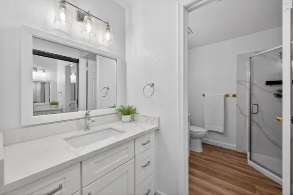a bathroom with a granite countertop sink toilet and shower