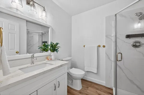 a bathroom with a sink a toilet and shower