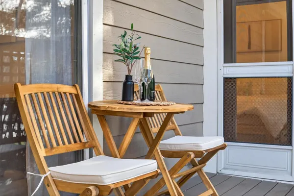 a balcony with wooden floor and outdoor seating