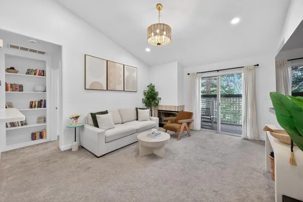 a living room with furniture a flat screen tv and a large window