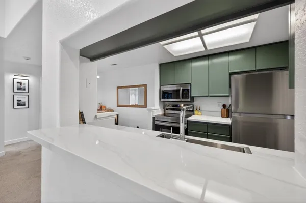 a kitchen with stainless steel appliances a refrigerator and a stove top oven