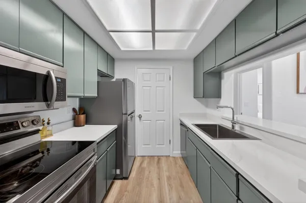a kitchen with stainless steel appliances a sink stove and refrigerator