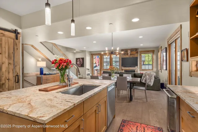 a kitchen island with stainless steel appliances kitchen island granite countertop a sink and a living room view