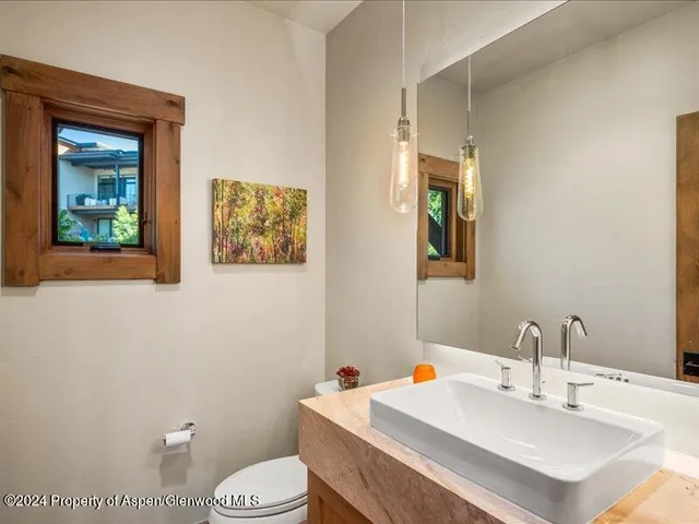 a bathroom with a sink mirror and toilet