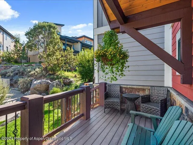 a balcony with wooden floor outdoor seating and stairs