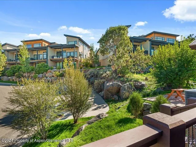 a front view of a house with a yard and potted plants