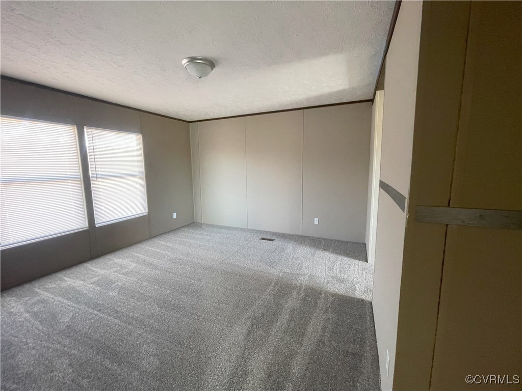26286 Peters Bridge Road Courtland, VA 23837 - Photo 26 of 32 Carpeted empty room with a textured ceiling