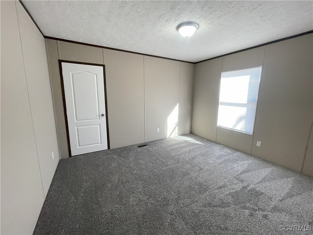 26286 Peters Bridge Road Courtland, VA 23837 - Photo 28 of 32 Carpeted empty room with a textured ceiling
