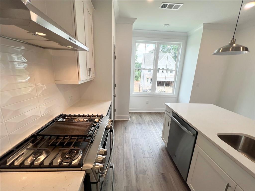 635 Silva Street, Unit 131 Cumming, GA 30040 - Photo 12 of 67 a kitchen with wooden floor a stove and a window