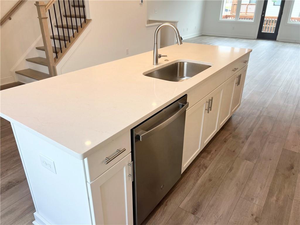 635 Silva Street, Unit 131 Cumming, GA 30040 - Photo 13 of 67 a kitchen with a sink a refrigerator and wooden floor