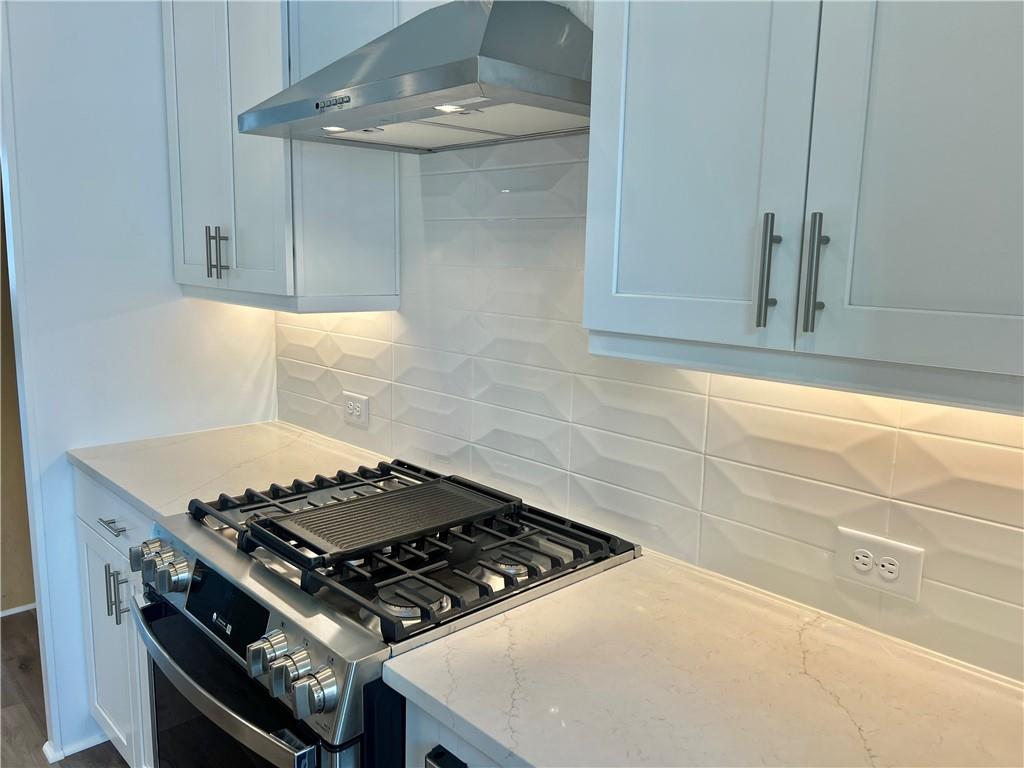 635 Silva Street, Unit 131 Cumming, GA 30040 - Photo 16 of 67 a stove top oven sitting inside of a kitchen