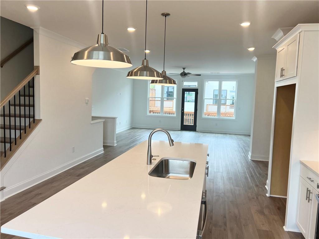 635 Silva Street, Unit 131 Cumming, GA 30040 - Photo 18 of 67 a kitchen with kitchen island a refrigerator and a wooden floor