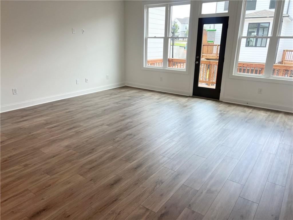635 Silva Street, Unit 131 Cumming, GA 30040 - Photo 23 of 67 a view of an empty room with wooden floor and a window