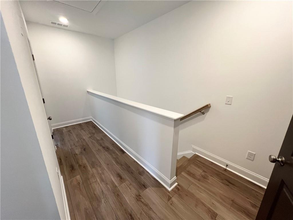 635 Silva Street, Unit 131 Cumming, GA 30040 - Photo 28 of 67 an empty room with wooden floor and white walls