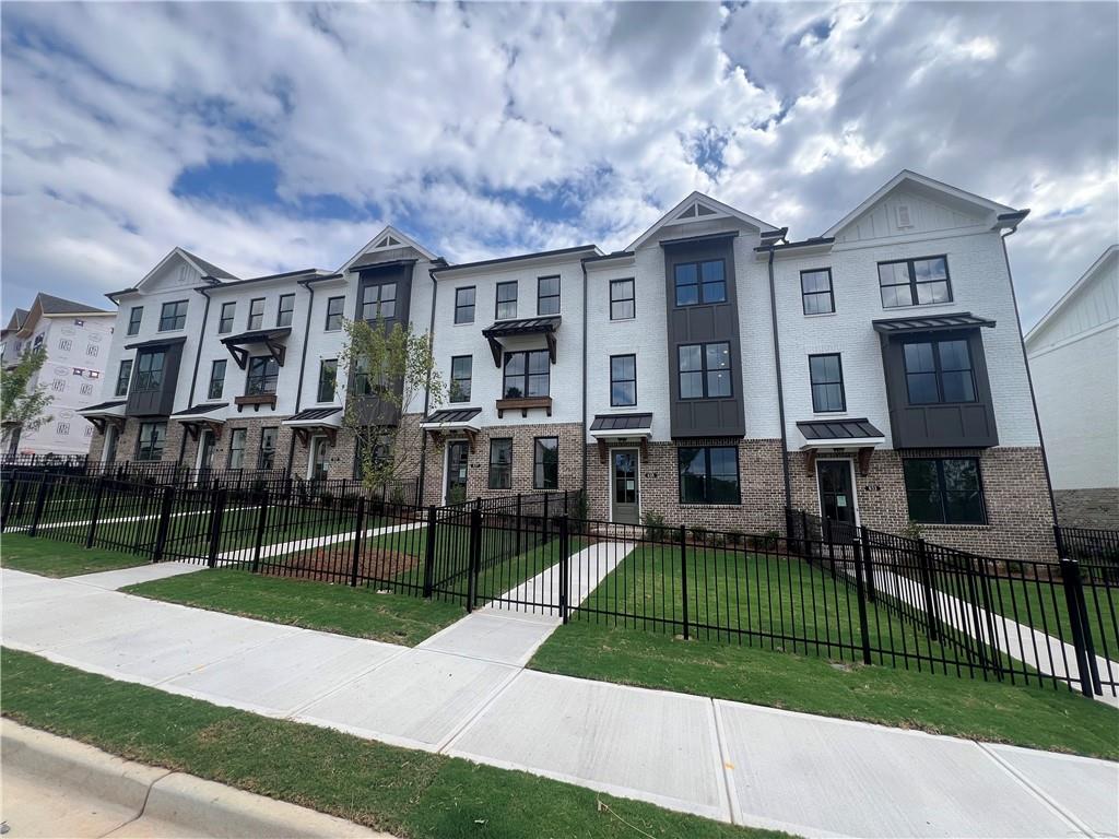 635 Silva Street, Unit 131 Cumming, GA 30040 - Photo 6 of 67 a view of a big house with a big yard and large trees