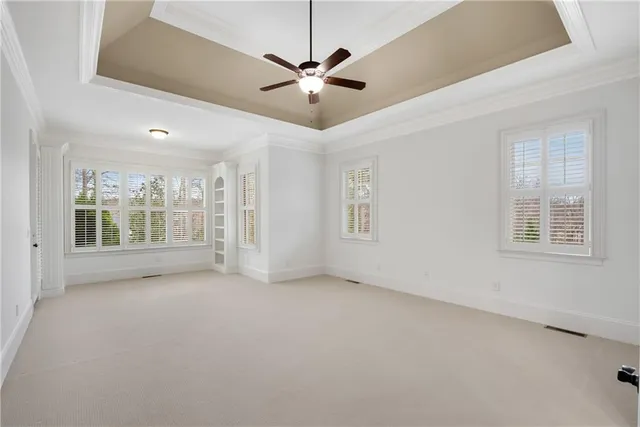 an empty room with a ceiling fan and window