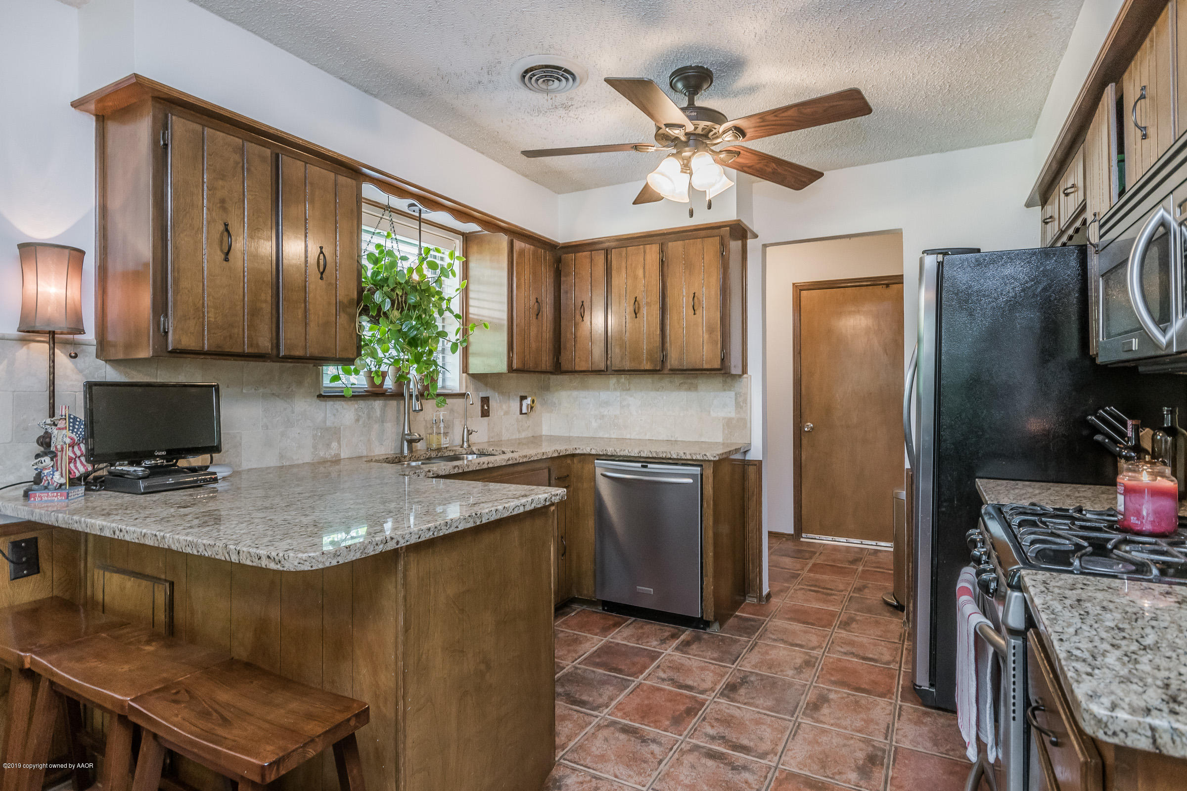 5264 Capulin Lane Amarillo, TX 79110 - Photo 5 of 22 a kitchen with kitchen island granite countertop a sink appliances cabinets and furniture