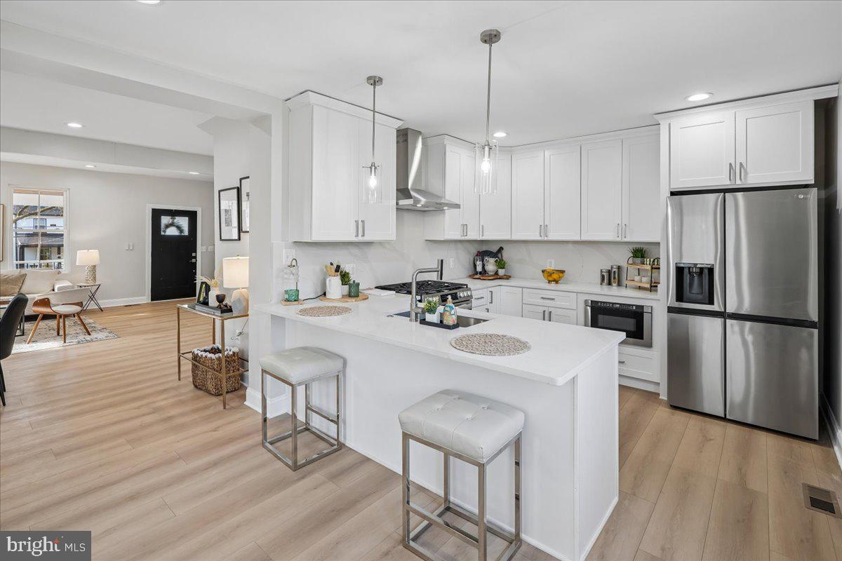 17 Longfellow Street Northwest Washington, DC 20011 - Photo 10 of 41 a kitchen with stainless steel appliances a refrigerator a stove a sink dishwasher and white cabinets with wooden floor