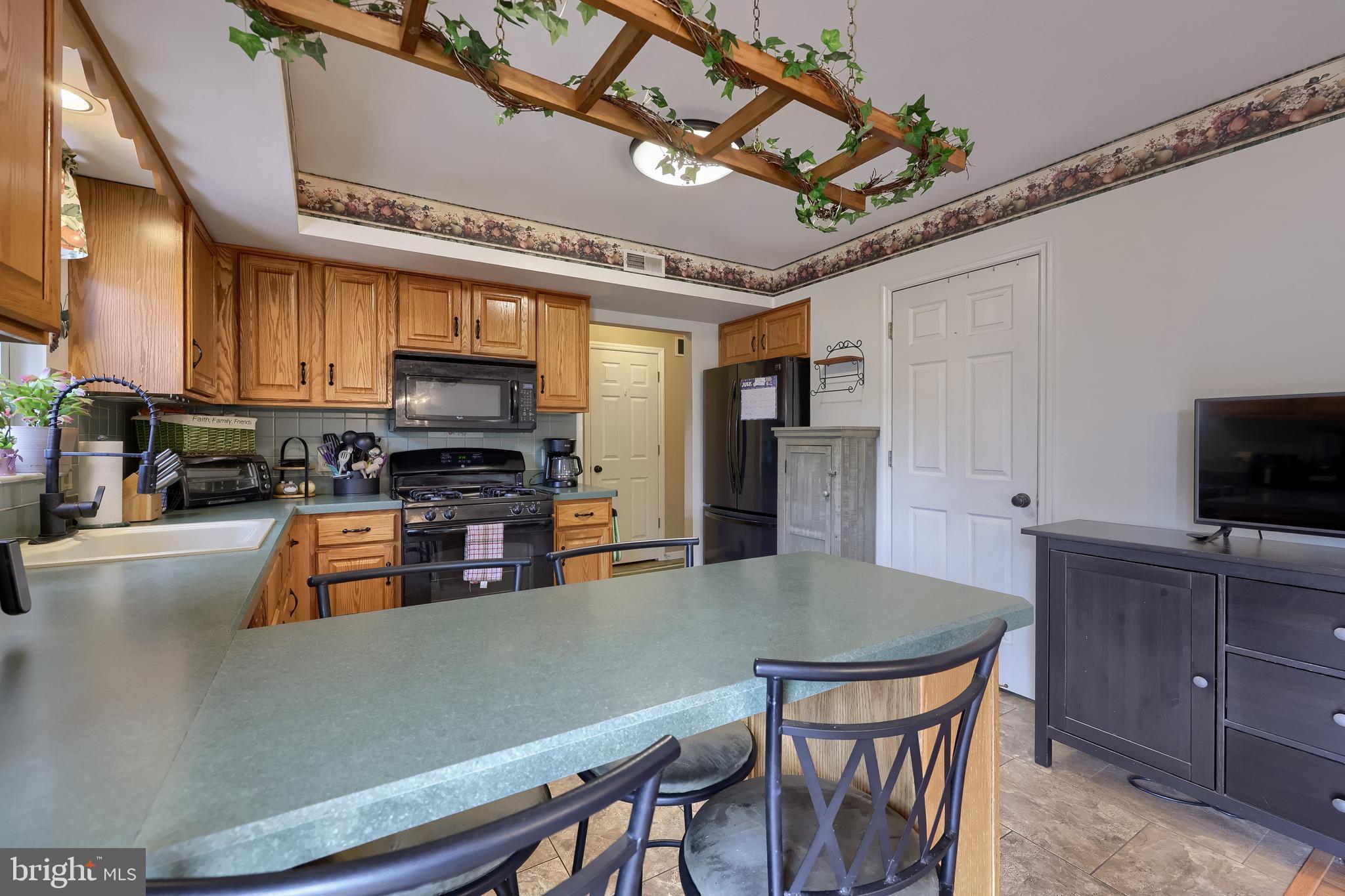 105 Bainbridge Circle Reading, PA 19608 - Photo 13 of 36 a kitchen with stainless steel appliances a table chairs microwave and cabinets