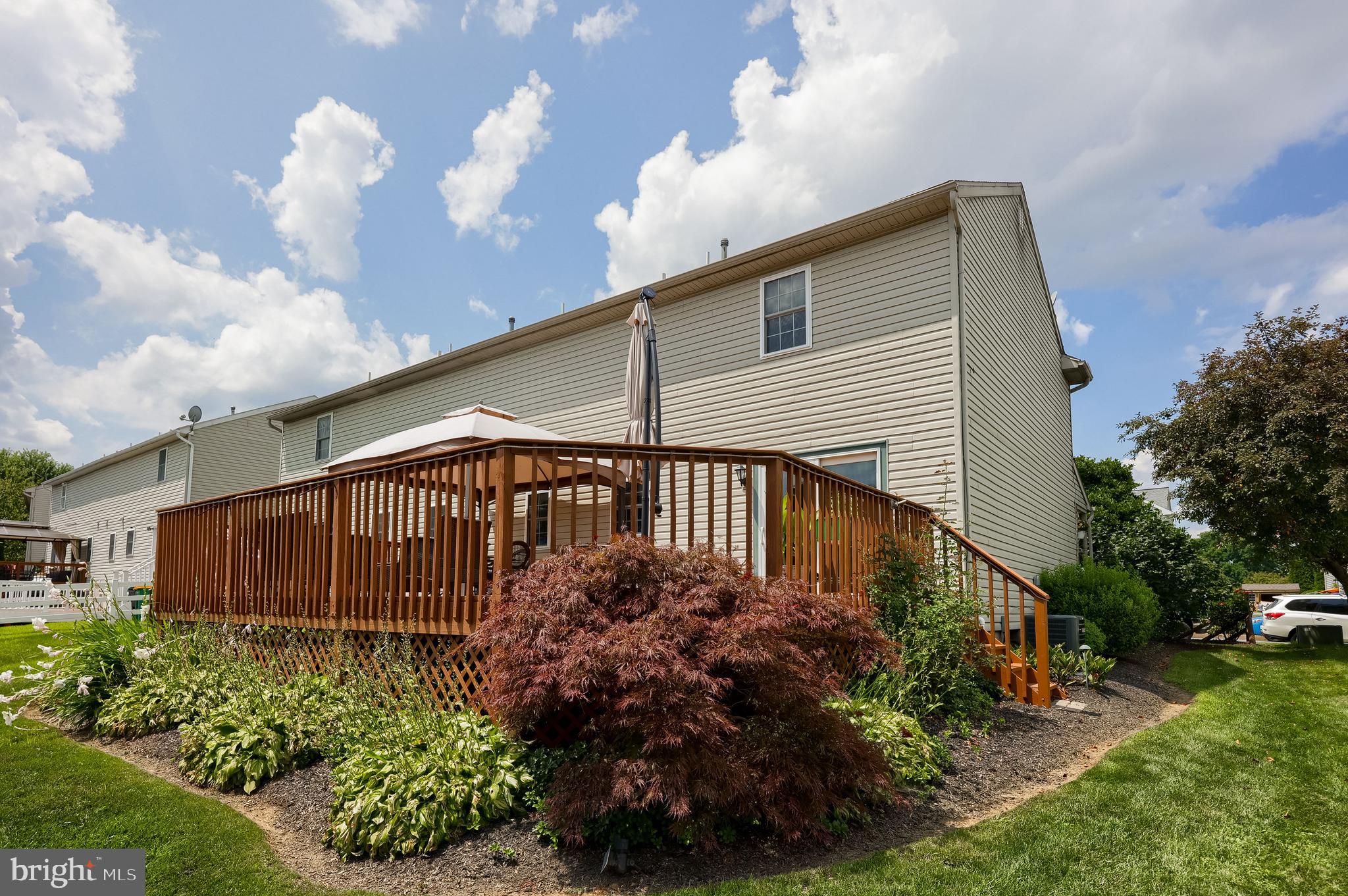 105 Bainbridge Circle Reading, PA 19608 - Photo 29 of 36 a backyard of a house with lots of flower plants and wooden fence