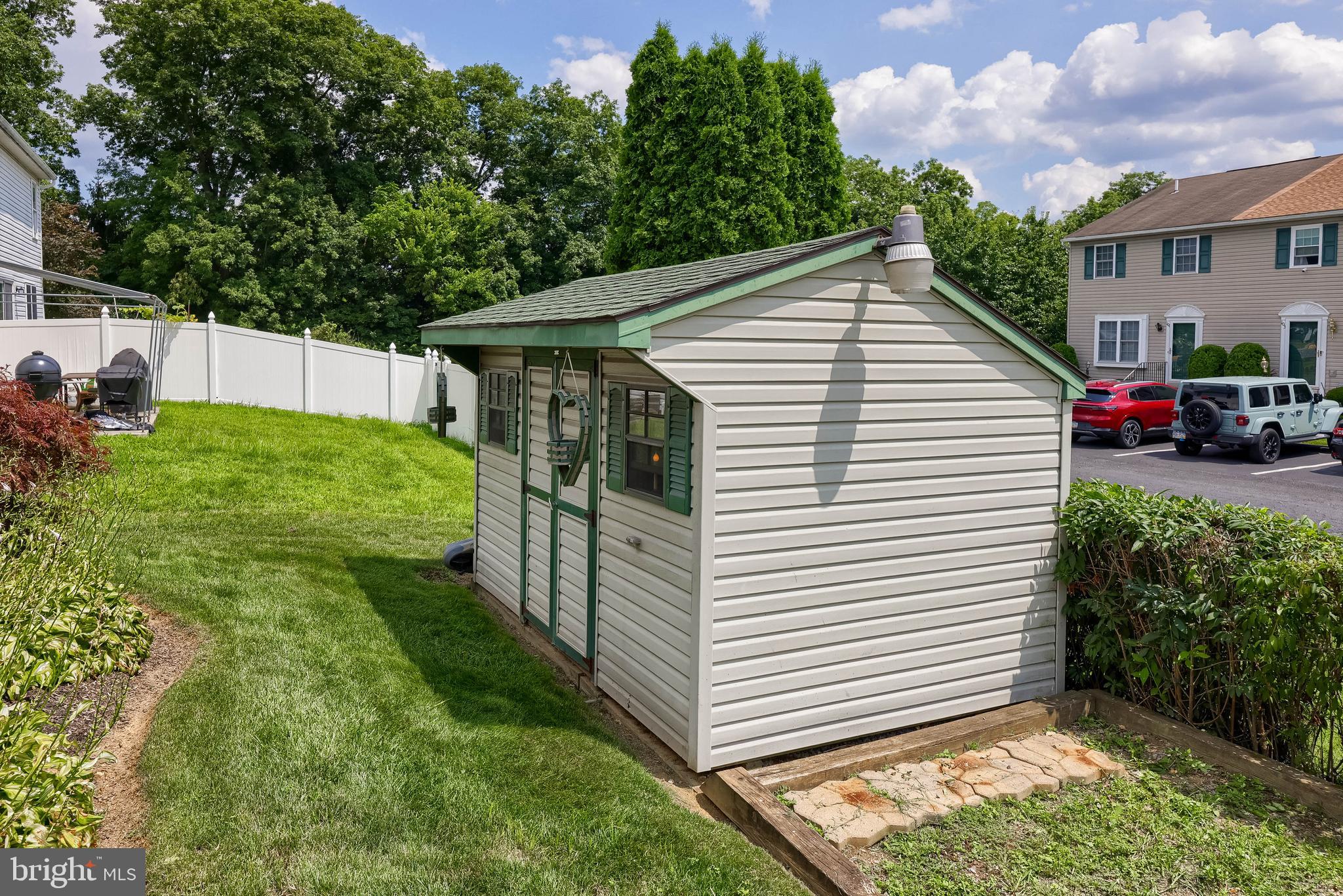 105 Bainbridge Circle Reading, PA 19608 - Photo 31 of 36 a view of a white house with a yard and table and chairs under an umbrella