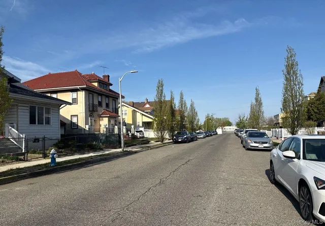 a view of a street with a cars parked in front of it