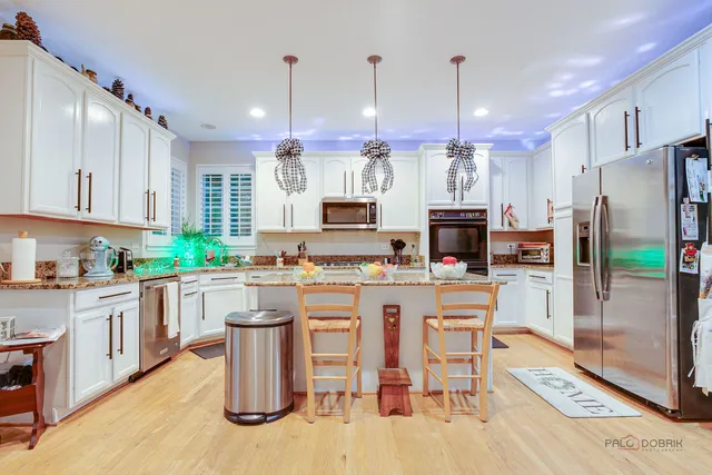 a kitchen with kitchen island granite countertop a sink a counter top space stainless steel appliances and cabinets
