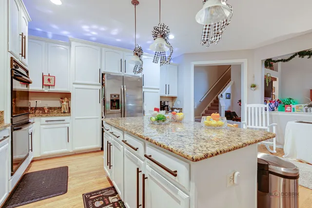 a kitchen with stainless steel appliances granite countertop a sink dishwasher and a refrigerator