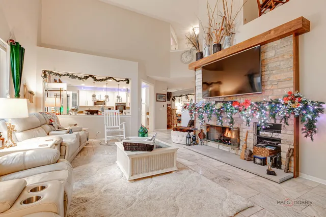 a living room with furniture a flat screen tv and a fireplace