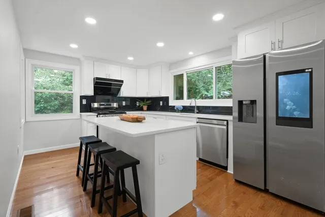 a kitchen with a sink a window stainless steel appliances and cabinets