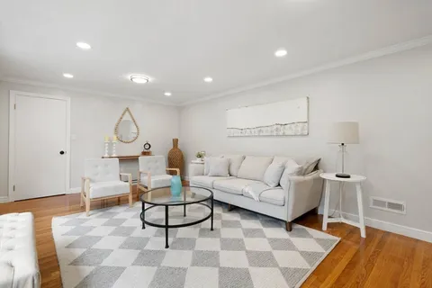 a living room with furniture a clock and a rug