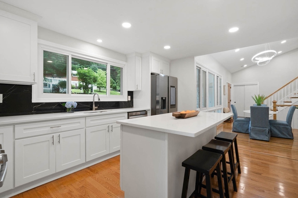 7 Thornberry Road Winchester, MA 01890 - Photo 2 of 35 a kitchen with stainless steel appliances a table chairs and a refrigerator