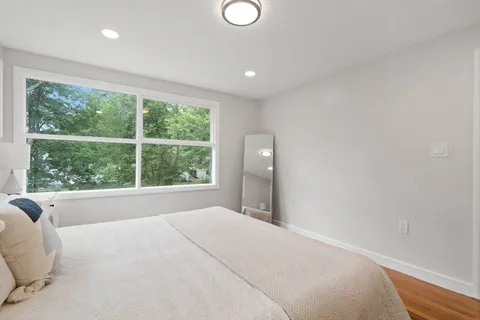 a large bed sitting in a bedroom next to a window