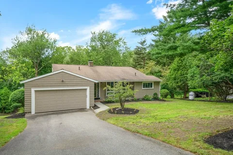 a front view of a house with yard and green space