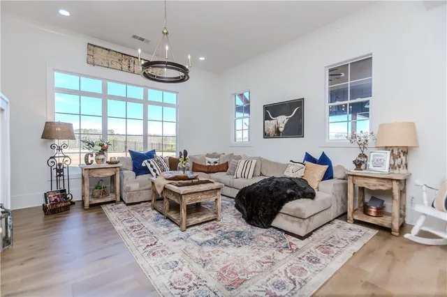 a living room with furniture flat screen tv and a large window